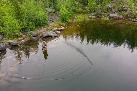Fisherman man in river fly fishing salmon, morning.の写真素材