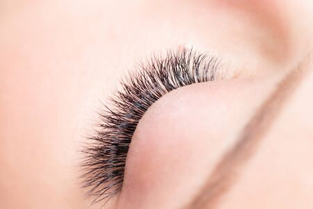 Eyelashes extensions procedure in spa beauty salon. Macro Beautiful eye with makeup, top viewの写真素材