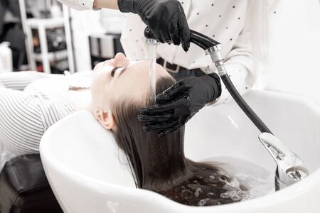 Care of scalp, hair structure against loss and baldness. Wash procedure in sink. Beauty salon spaの写真素材