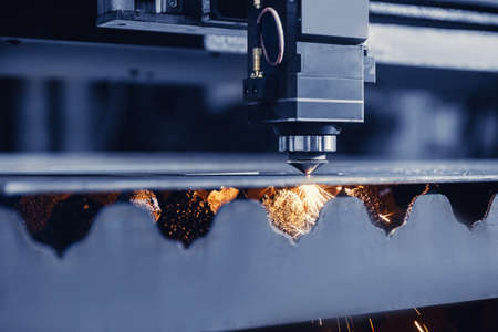 CNC laser machine cutting sheet metal with light spark. Technology plasma industrial, Blue steel colorの写真素材