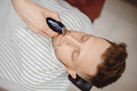 Hipster client man visiting in barber shop shaving beardの写真素材