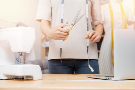 Banner professional tailor young woman designs holds scissors clothes in designer workshop studio