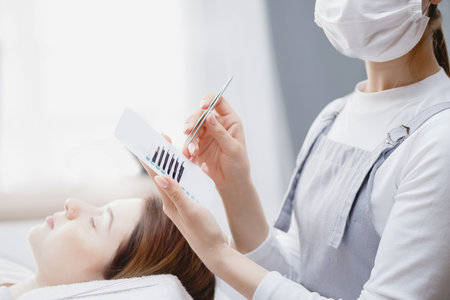 Master making fake long lash Eyelash extension procedure with tweezers for woman