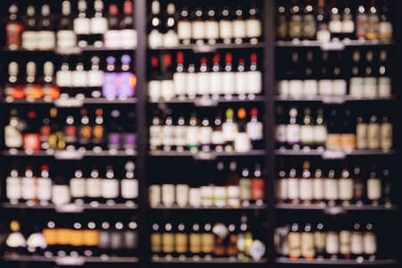Many glass wine bottles on shelves interior in restaurant. Blurred backgroundの写真素材