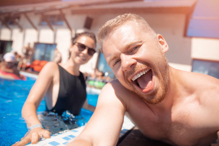 Couple happy caucasian beautiful young woman and man make selfie photo on background swimming pool....