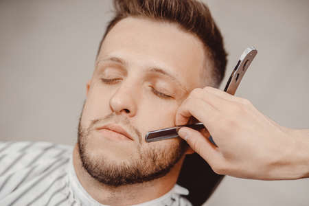 Barber beard styling and cut process. Barbershop for menの写真素材