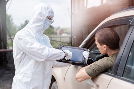 Concept ban driver car travel coronavirus. Doctor in protective virus suit taking registering for...