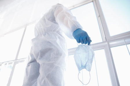 Nurse hold protection face mask against coronavirus. Banner medical staff biohazard preventive gear