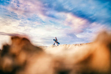 Man sand boarder standing on top with snowboard before extreme downhillの写真素材