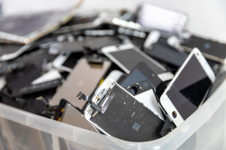 Broken iPhone Apple phone screens and used rechargeable batteries in recycling repair shop, RUSSIA -...