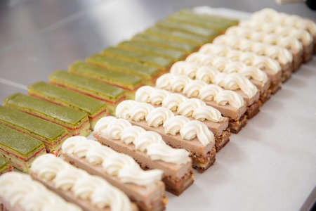 Close-up shot of row of fresh chocolate biscuits and brownies with nuts and pistachios cateringの写真素材