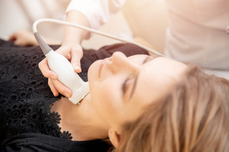 Woman getting ultrasound test thyroid from doctor in clinic