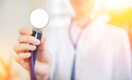 Stethoscope or phonendoscope in hand doctor woman in white uniform, Sunlightの写真素材