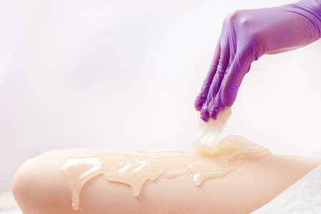 Removing hair from skin of feet with liquid sugar paste, renewing epithelium and cleansing pores from acneの写真素材