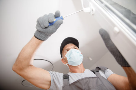 Worker man installs plastic windows and doors with double-glazed white