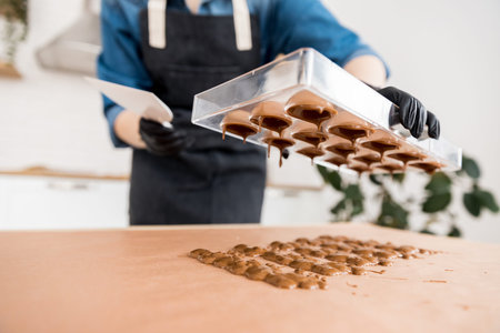 Confectioner girl holds form for candy made of Belgian chocolateの写真素材