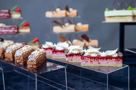 Sweet dessert table for catering and wedding with chocolate brownies and muscakes on dark backgroundの写真素材