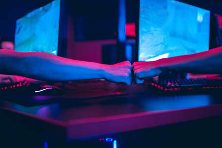 Professional gamer playing online games tournaments pc computer with headphones, Blurred red and blue backgroundの写真素材