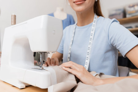 Close-up of seamstress threading needle in sewing machine
