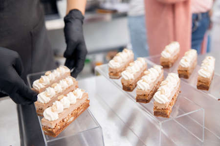 Decor of cakes with chocolate and nuts, close-up of serving sweets in restaurant in kitchenの写真素材