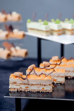 Sweet dessert table for catering and weddings, chocolate cake with mango and butter cream