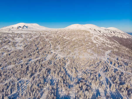 Sheregesh ski lift resort in winter, landscape on mountain and hotels, Aerial top view beautiful forest of Russiaの写真素材