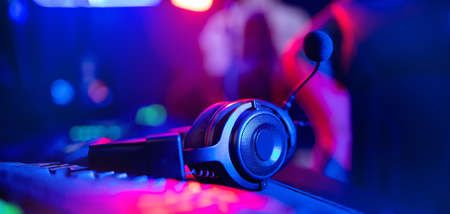 Headphones with microphone for video games and cyber sports on neon background of gaming monitorの写真素材