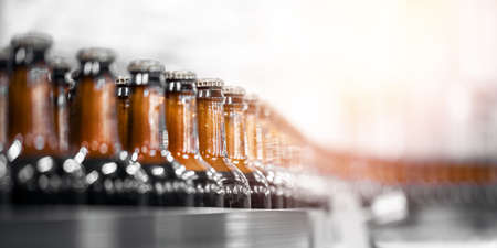 Beer bottles on conveyor production line belt. Brewery factory manufacturing plantの写真素材