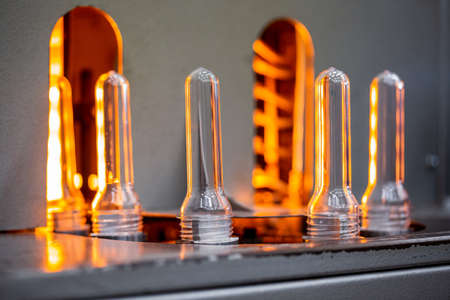 Preforms for making PET plastic bottles. Blank for production of containers for milk or beer. Line factory industry equipmentの写真素材