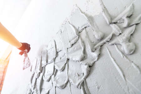 Initial application of putty and plaster on concrete wall to level surfaceの写真素材