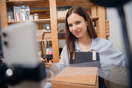 Online tutorial gift wrapping, young woman records Internet video on phone