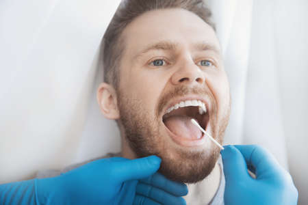 Medical test young man for dangerous virus using test swab stickの写真素材