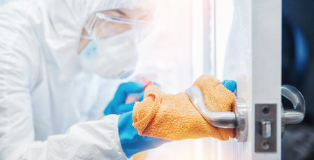 Medical staff disinfection sanitize door handles from pandemic infection with virus and microbes in...