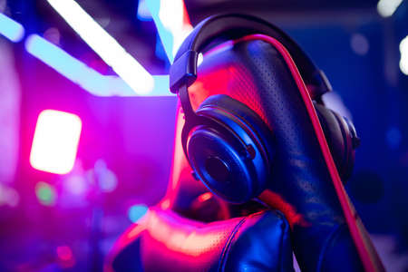 Professional gamers room with headphones microphone for cyber esports and video games on neon background of gaming monitorの写真素材