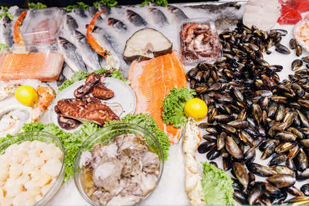 Sea market, fresh farmed mussels, octopus, trout crab and scallop meat on table with ice saladの写真素材