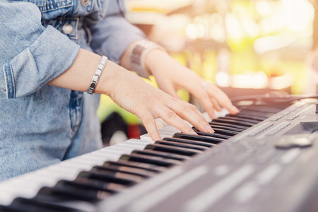 Closeup of thumbs up street musician woman playing on mobile pianoの写真素材