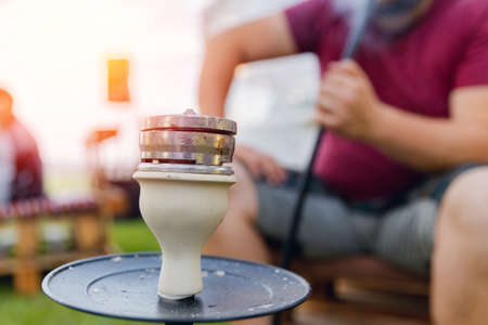 Hookah against background of group of friends. Conception is recreation on landscape campaign holidaysの写真素材