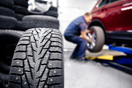Concept car service replacement of winter and summer tires. Mechanic holding wheels at garage