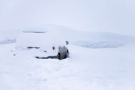 Car under snow blocked in parking snowstorm winter frost.の写真素材