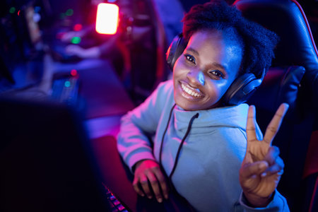Happy Streamer gamer African American young girl smiles and play video game