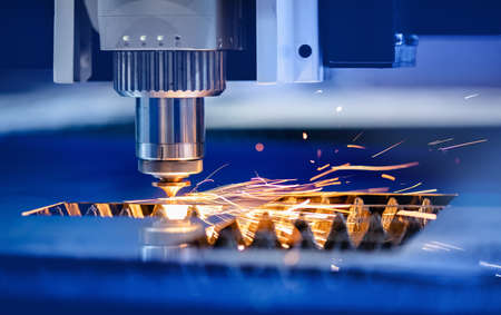 CNC Laser engraving cutting of heavy metal with light spark. Concept background modern industrial technologyの写真素材