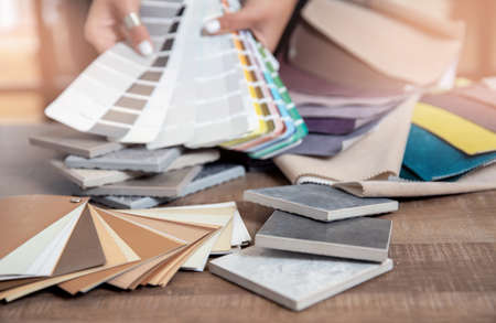 Interior designer decorator choosing wall paint color to match with chooses fabrics for furniture upholstery, curtains in textile set for apartmentの写真素材