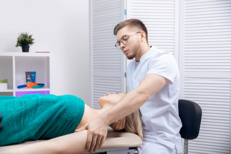 Therapist osteopathy working sports massage with shoulders of woman athlete