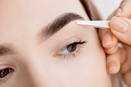 Master tweezers depilation of eyebrow hair in women, brow correction