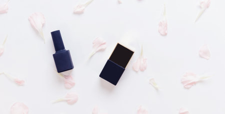 Organic natural nail polish bottles with flowers on white background, top view bannerの写真素材