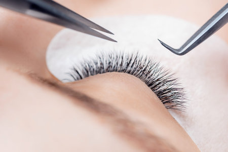 Eyelash extension procedure microblading for woman in beauty salon