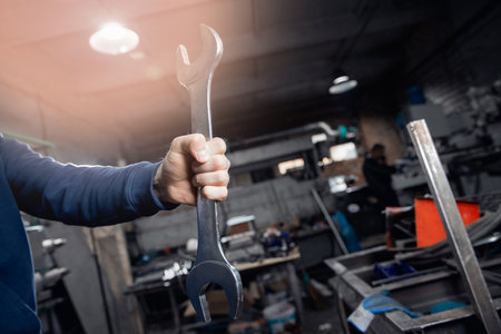 Wrench in hands of professional turner man metal working on factoryの写真素材