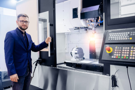 Modern process metal detail production going for car. Worker man entering data in CNC drill machine...