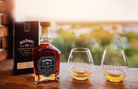 Russia - June 12. 2021, Glass bottle of Jack Daniels Tennessee whiskey on sunset wood toning backgroundのeditorial素材
