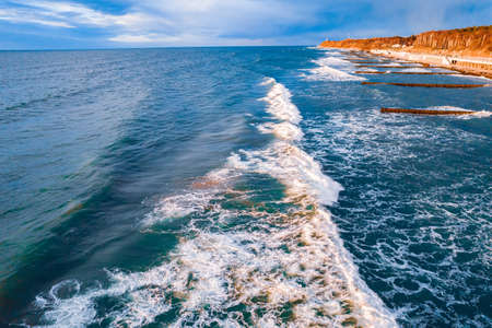 Foamy wave of clear turquoise ocean water near sandy shore, Aerial top viewの写真素材